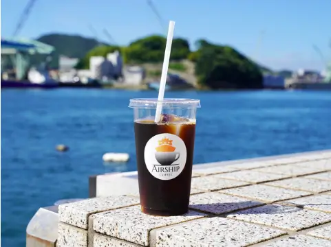 海辺を背景にアイスコーヒーの写真